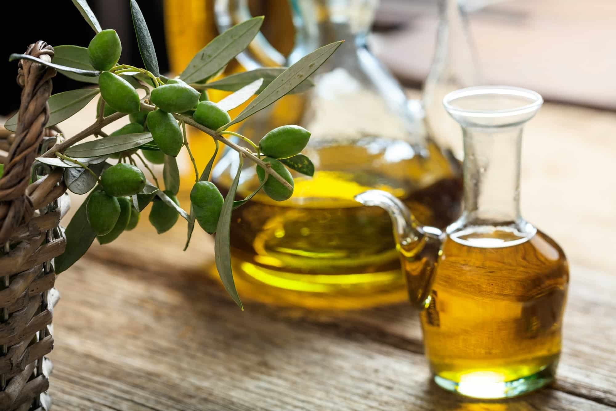 Olive oil and olive twig on a table